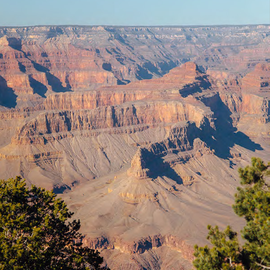 Sweeping view of the Grand Canyon's layered rock formations at golden hour.