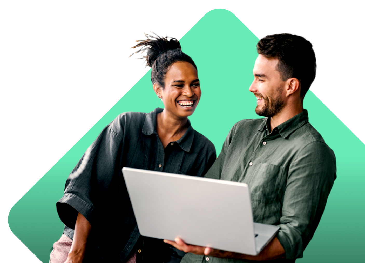 A woman and a man smiling at each other, with the man balancing a laptop on his left hand.