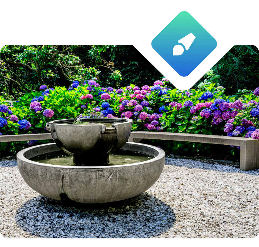 Still image of a stone fountain in a botanical area.